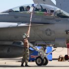 Upon arrival, NAS airmen wash the cockpit glass as aviators scan the scene for family members.